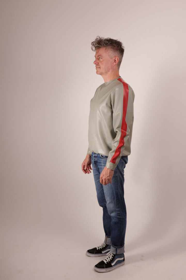 Fabian half turned from the camera in his grey latex sweatshirt with red stripes on the arms.