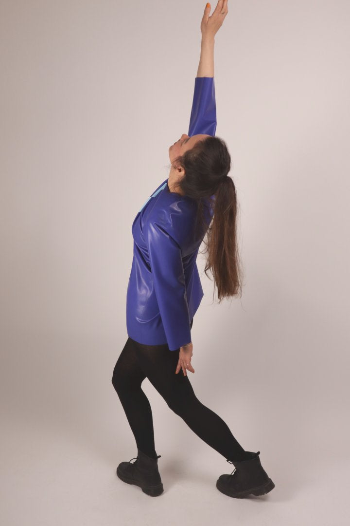 our model doing a yoga move in a blue latex 60s long sleeve mini dress