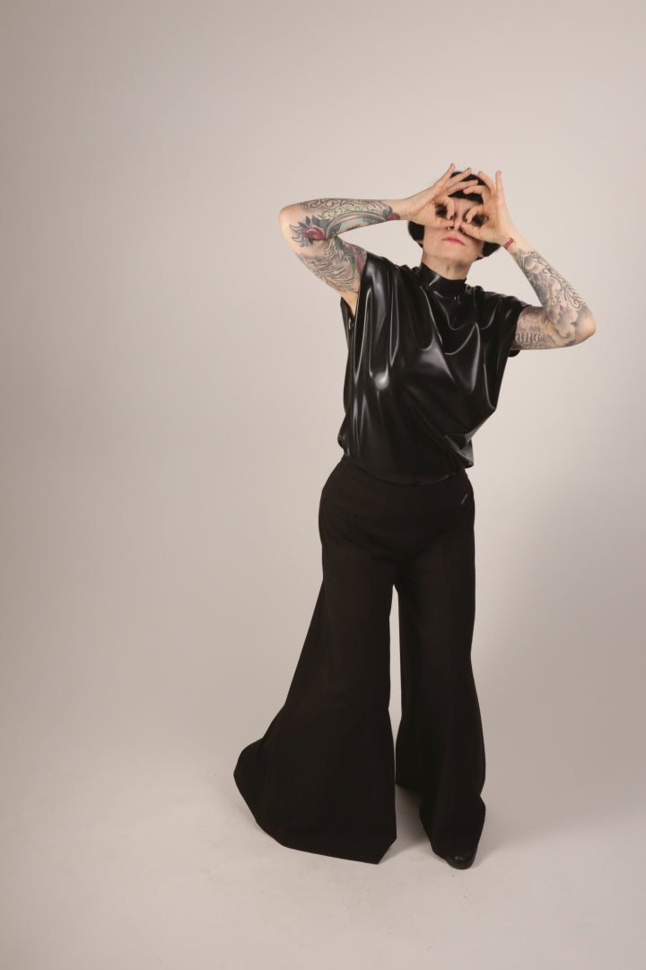 Anja in our black sleeveless latex 60s top mimicking binoculars.
