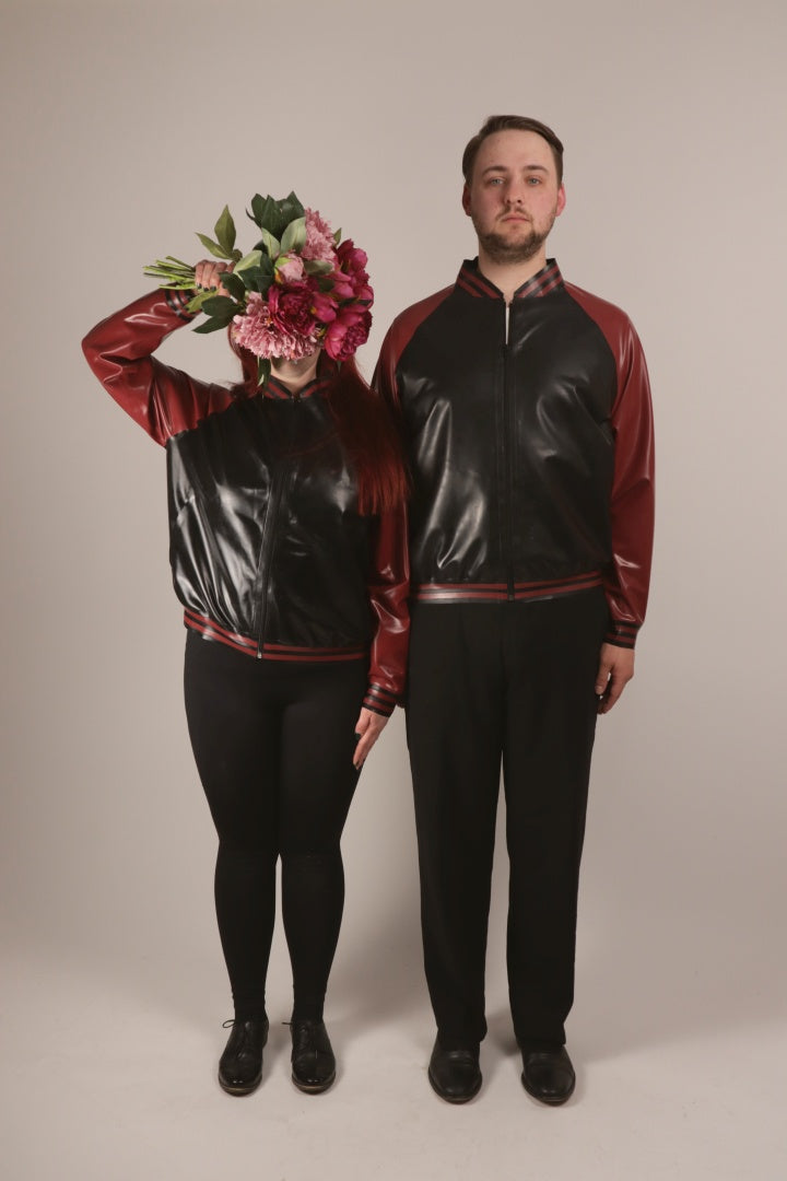 Sarah and Paul standing attention in our black and wine-red latex varsity jacket with pockets. Sarah's face is hidden behind a flower bouquet.