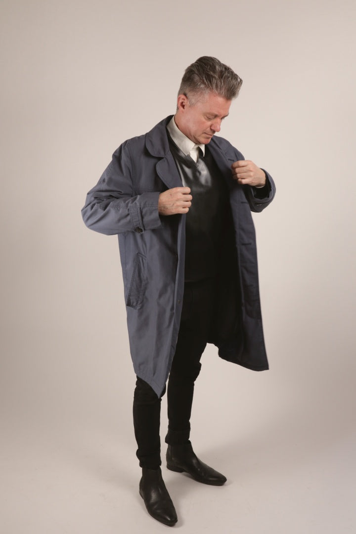 Our male model wearing our new TARZA & JANE latex V-neck sweater in a business fashion over a dress shirt and under a top coat.