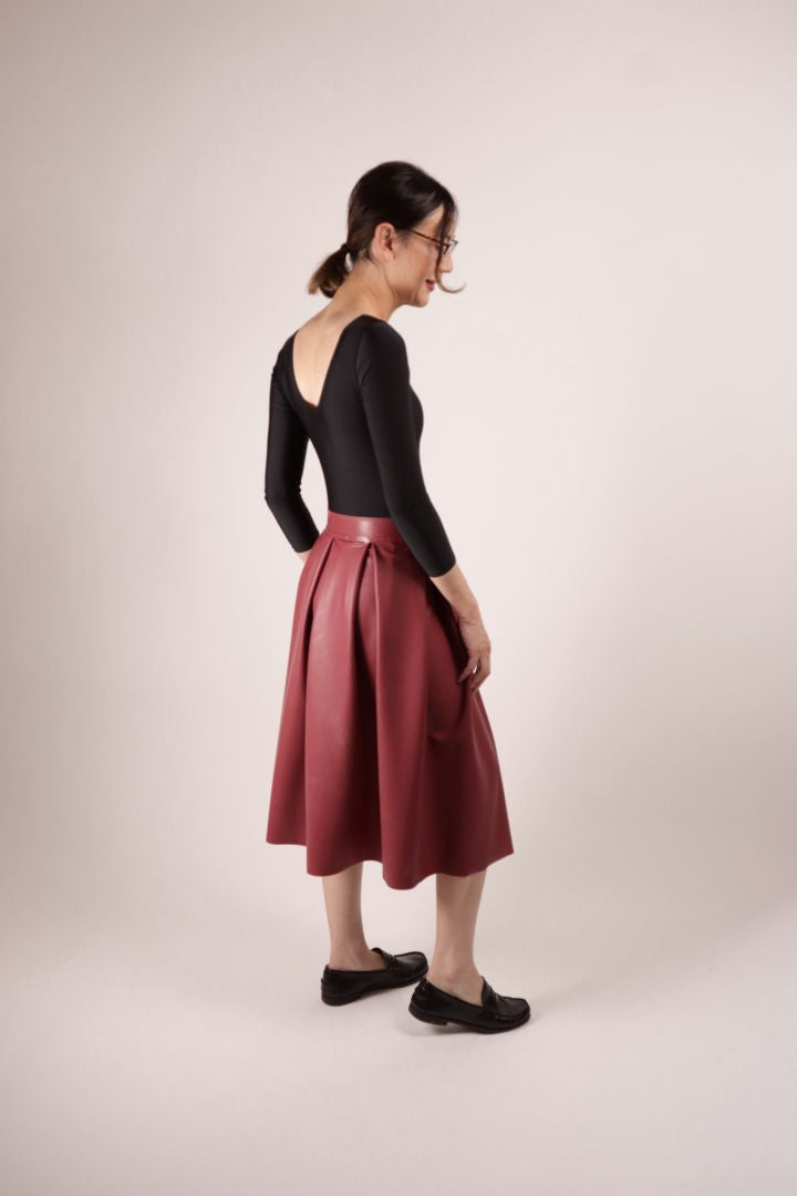Our model Hani in our TARZA & JANE bordeaux red demi latex pleat skirt, a black ballet leotard and loafers