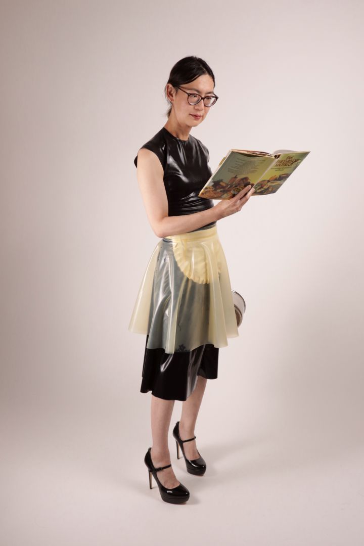 Hani reading a 70s vegetarian cook book. A fashionista in our TARZA & JANE impossible latex maid dress.