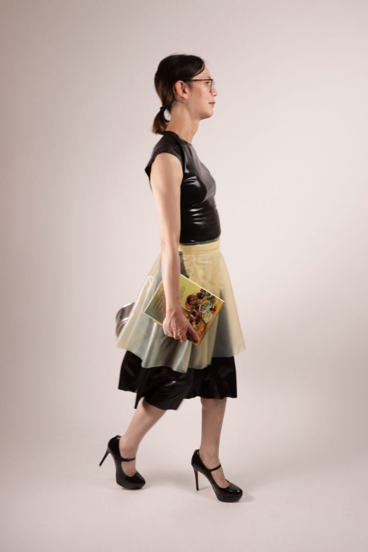 Our model Hani marching across the set with a vegetarian cook book in her right hand. A fashionista in our TARZA & JANE impossible latex maid dress.