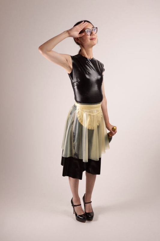 Hani stiffly saluting the god of champagne with a bottle of the latter dangling from her left hand. All of this in our TARZA & JANE impossible latex maid dress.