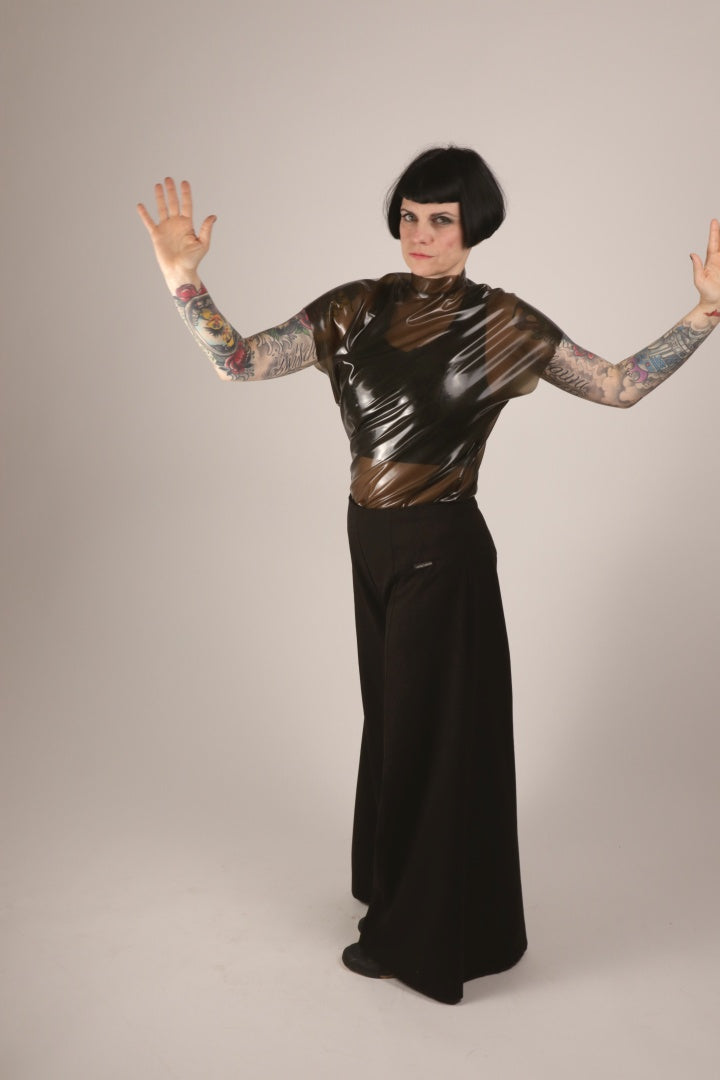 Our model Anja twisting her upright silhouette in her transparent-black latex loose sleeveless top.