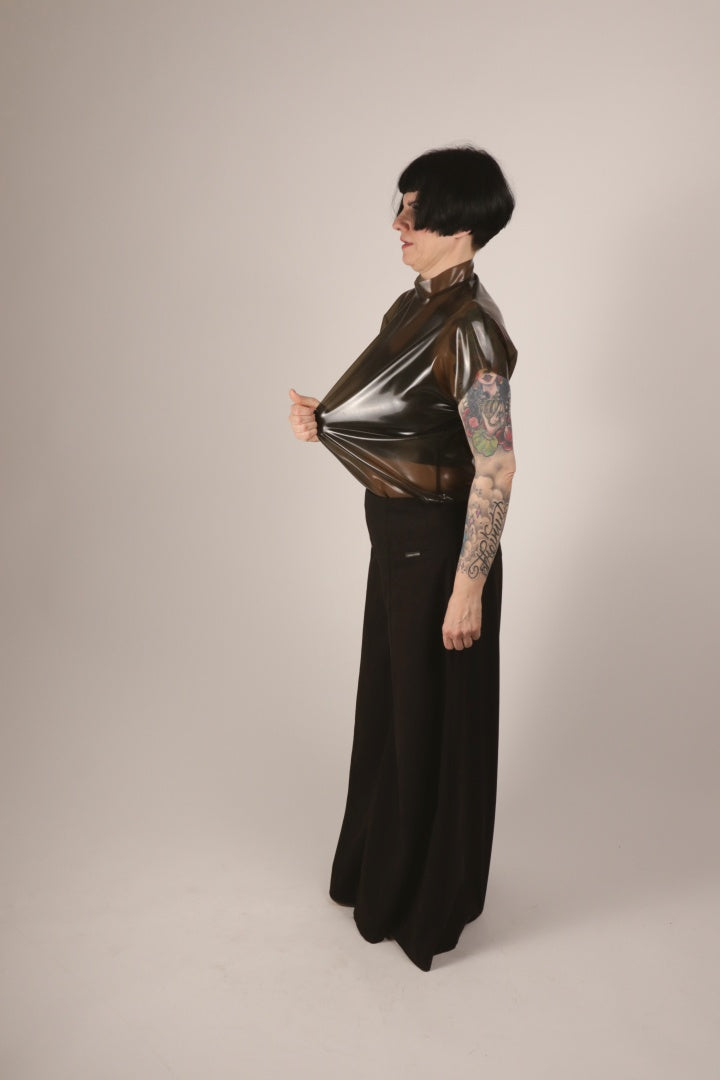 Anja pulling on the front part of her transparent-black latex sleeveless 60s top.