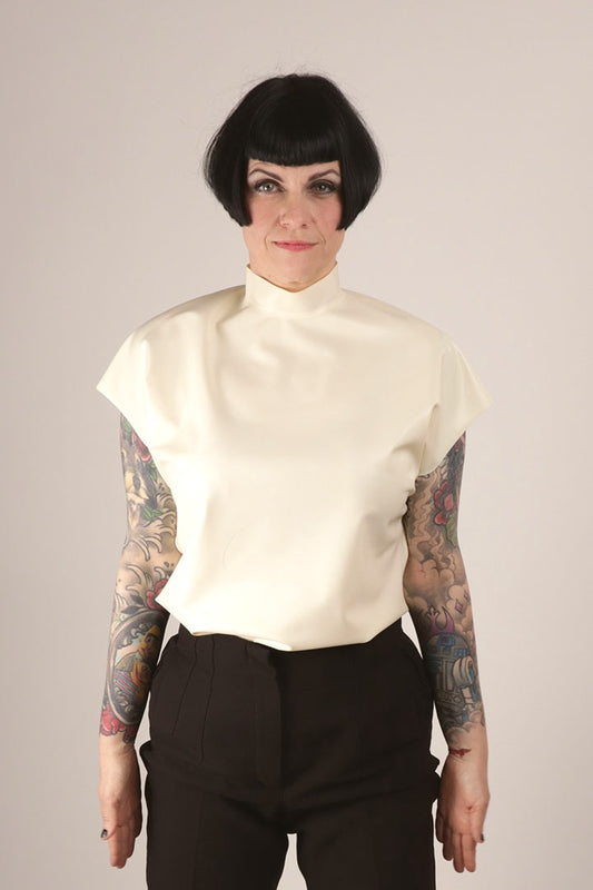 Close-up of Anja doing a ballet move in her white 60s sleeveless latex top.