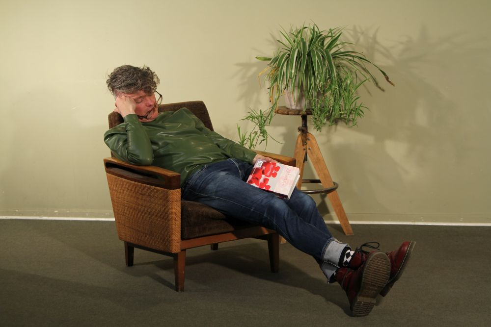 model-in-olive-green-latex-turtleneck-falling-asleep-reading