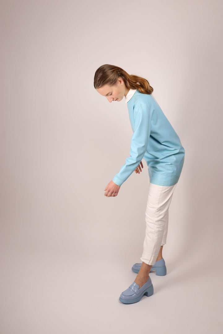 model in baby blue latex sweatshirt dress combined with white skinny jeans and a cotton dress shirt