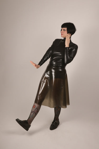 model Anja von Abels presenting her black latex turtleneck and her transparent black A-line skirt combined with fishnets and creepers.