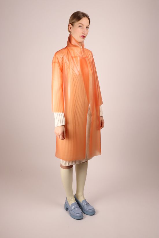 model-wearing-salmon-latex-coat-as-raincoat-with-collar-flipped-up
