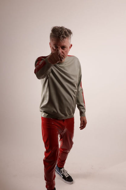Fabian doing a 'we want you' imitation  in his grey latex sweatshirt with red stripes on the arms, and red latex leggings and SK8 hi top Vans.