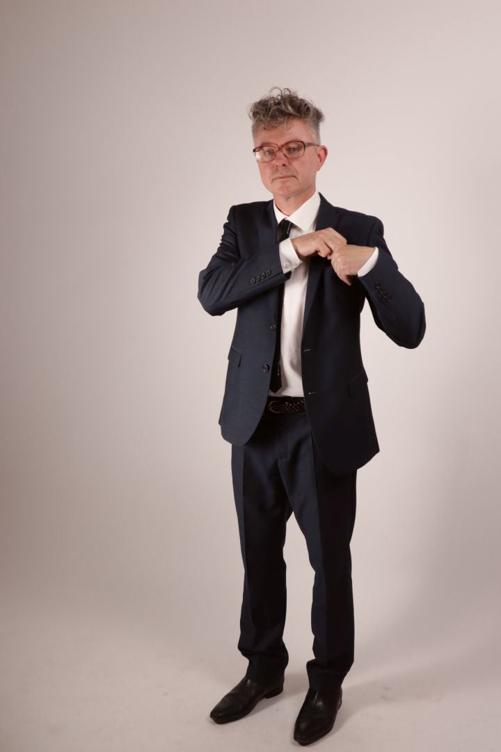 Our model Fabian tucking away his black latex pocket square after wiping his brow. He's in his navy blue business suit with a white dress shirt and his favorite new black narrow latex tie. 