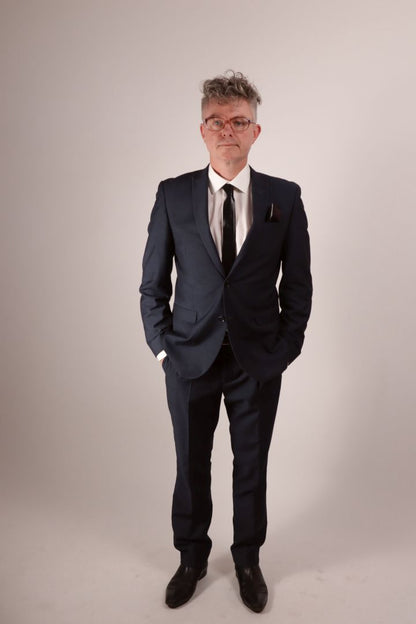 Our model Fabian in his a navy blue business suit with a white dress shirt and his favorite new black latex tie and matching pocket square. 