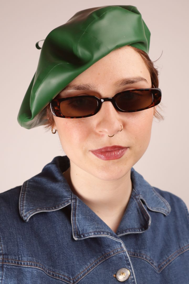 Annabel in narrow sunglasser and a forrest green latex beret cocked sideways