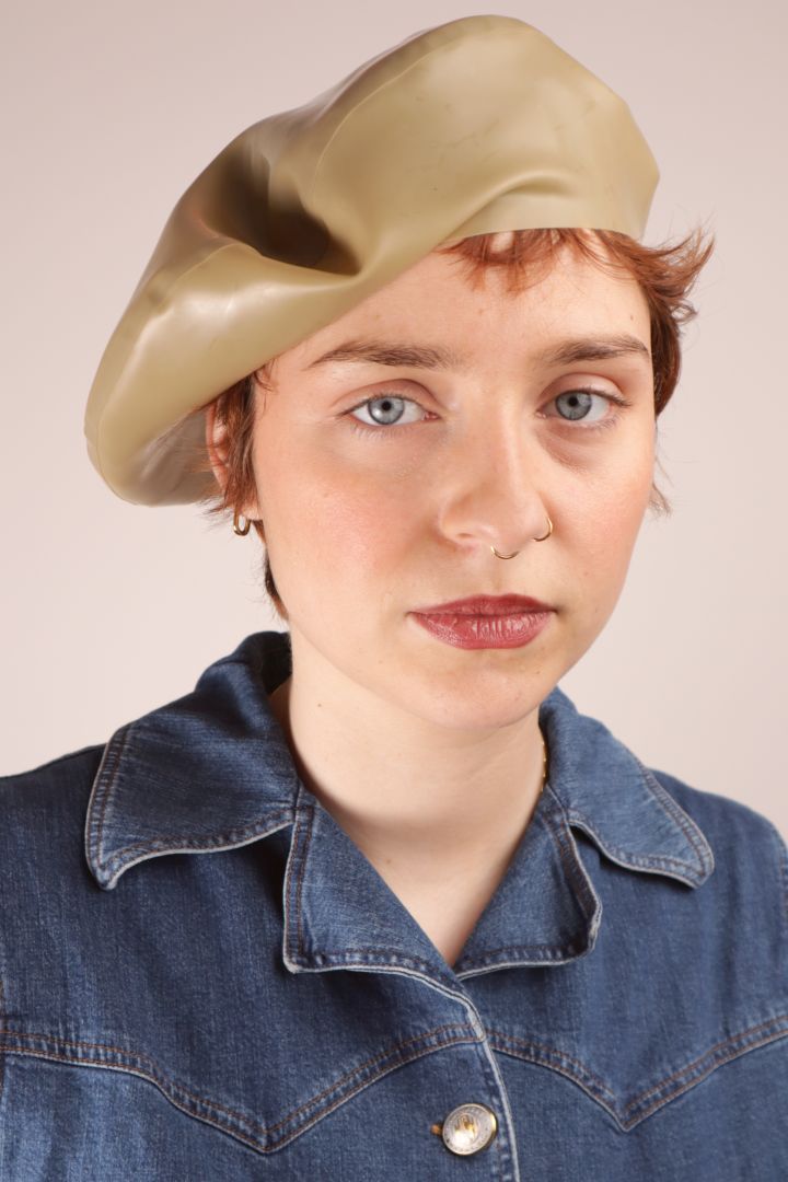 Annabel wearing our sand beige colored latex beret cocked sideways