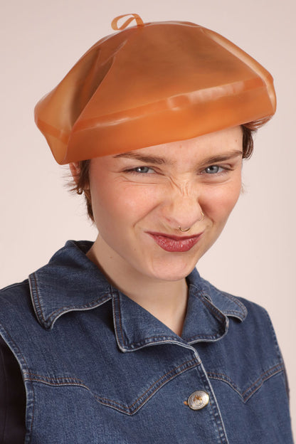 Annabel cringing and smiling at the same time, cutie. And she's wearing our transparent salmon latex beret.