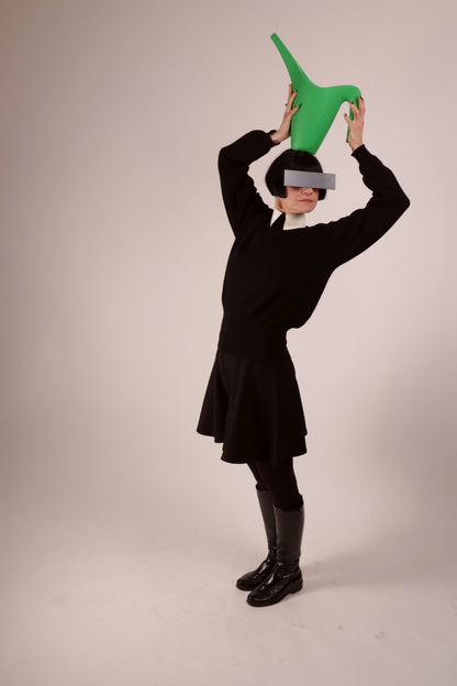 Anja sporting our warm white latex collar with press studs. She is wearing it over a black woolen sweater and with a black midi skirt and leather boots, and incognito sunglasses.
