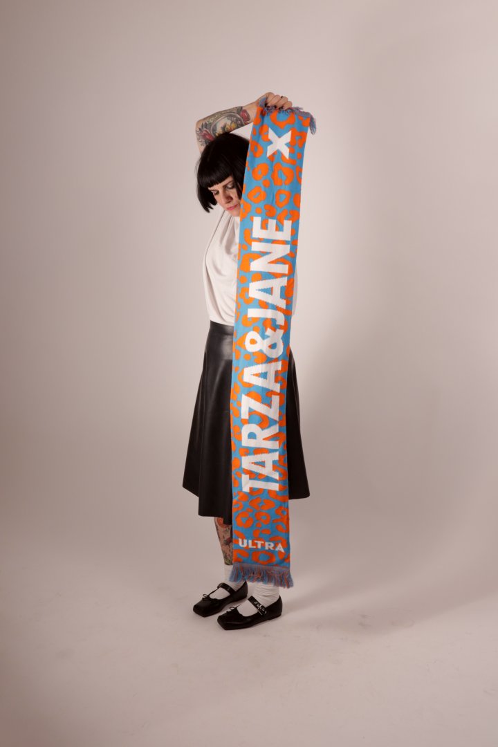Model Anja hiding behind her TARZA & JANE fan scarf. She is holding it vertically so you can see the design.