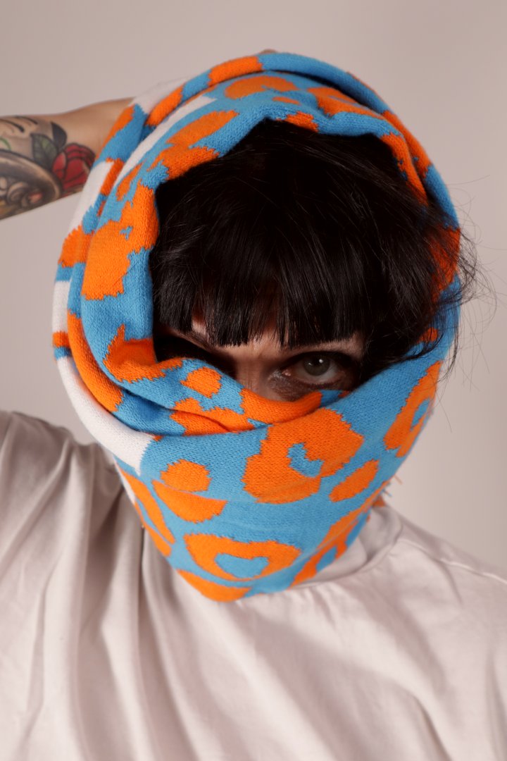 Close-up of Anja wrapping her fan scarf around her head. Only her black fringe and one eye looking out and staring at you intensely.