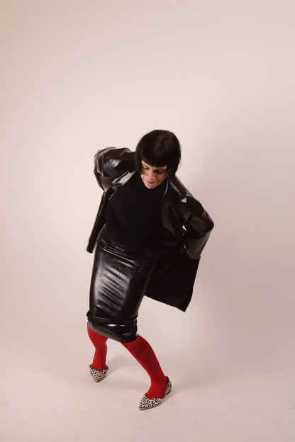 Our Model Anja von Abels twisting in our black latex pencil skirt and matching latex cocoon coat. She is wearing it over a red pantyhose and combines it with a black wool turtleneck and leopard print ballerinas.