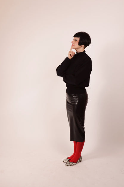Our model Anja in our black latex pencil skirt and a black woolen turtleneck. She combines it with a red pantyhose and leopard ballerinas.