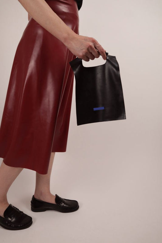 Model holding a latex purse or handbag in the form of a German plastic bag that the government recently prohibited.
