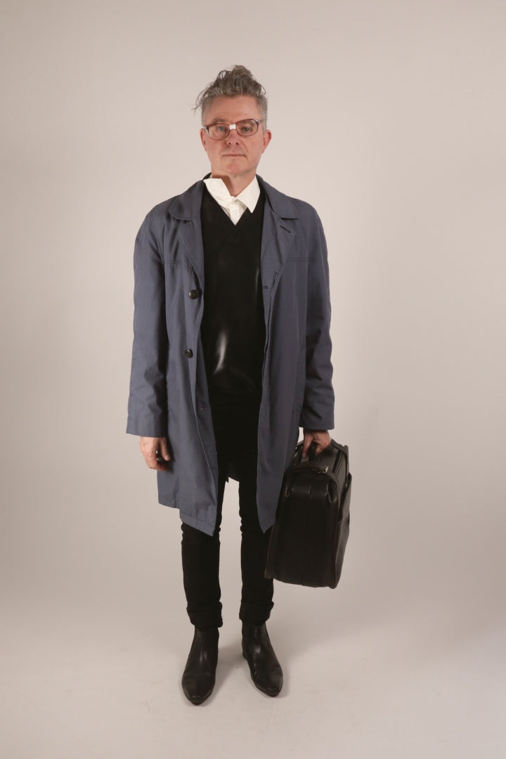 Our male model wearing our new TARZA & JANE latex V-neck sweater with a dress shirt, a top coat, and carrying a black briefcase. Looking very much beat up like Michael Douglas in the movie Falling Down.