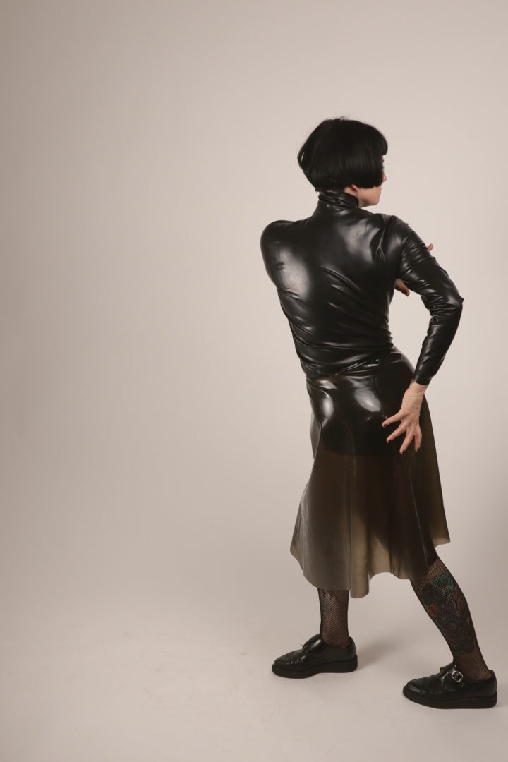 anja twisting in her translucent-black latex midi skirt and a black turtleneck