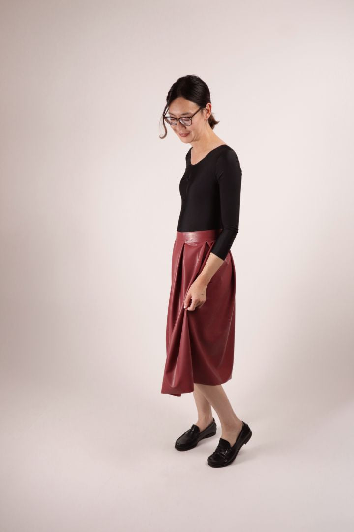 Our model Hani in our TARZA & JANE dark red demi latex pleat skirt key-piece, her black ballet leotard and loafers
