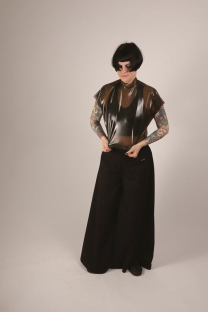Anja pulling on her transparent-black sleeveless latex 60s top.