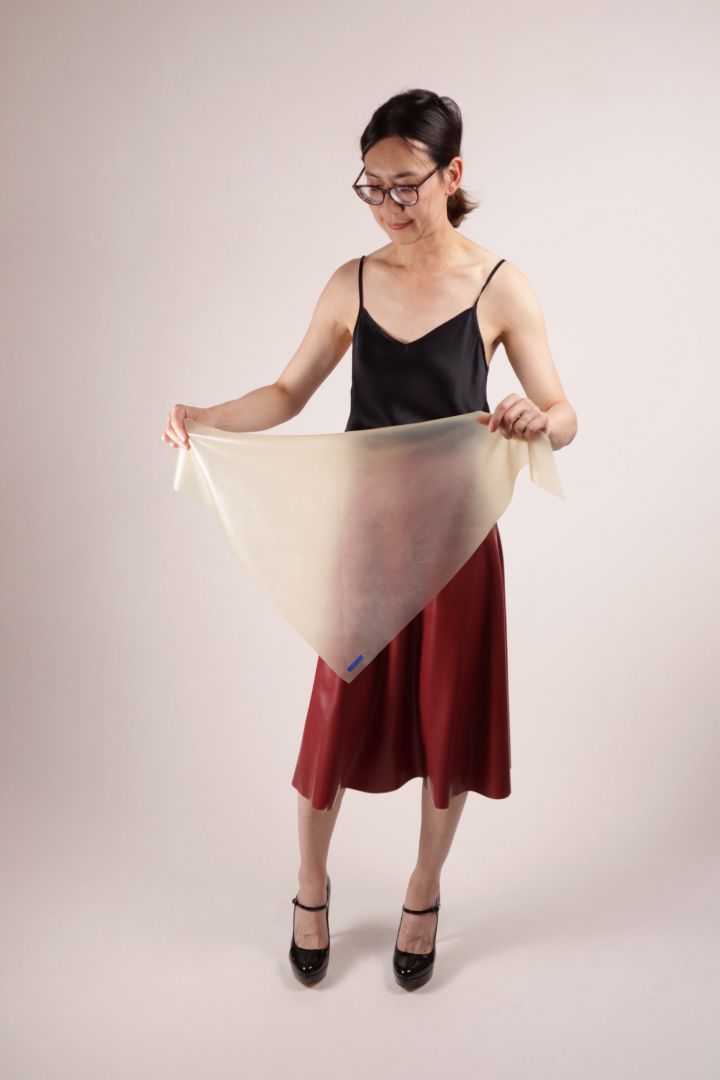 Hani demonstrating how to fold our TARZA & JANE latex scarf from a triangle into a neck adornment.