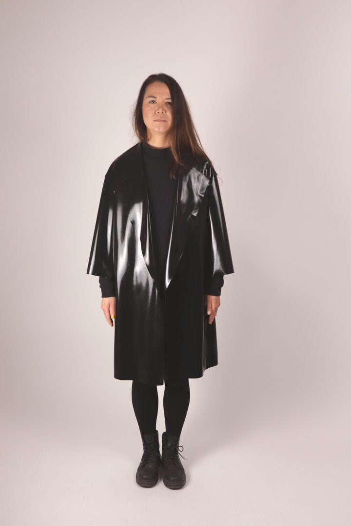 front view of christina in the tarza & jane latex coat. she wears it loose and without a belt.