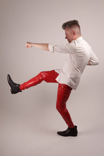 Fabian in red mens latex rubber leggings and a starched white shirt doing a carate move