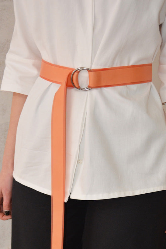 transparent-salmon-latex-belt-over-white-dress-shirt-closeup