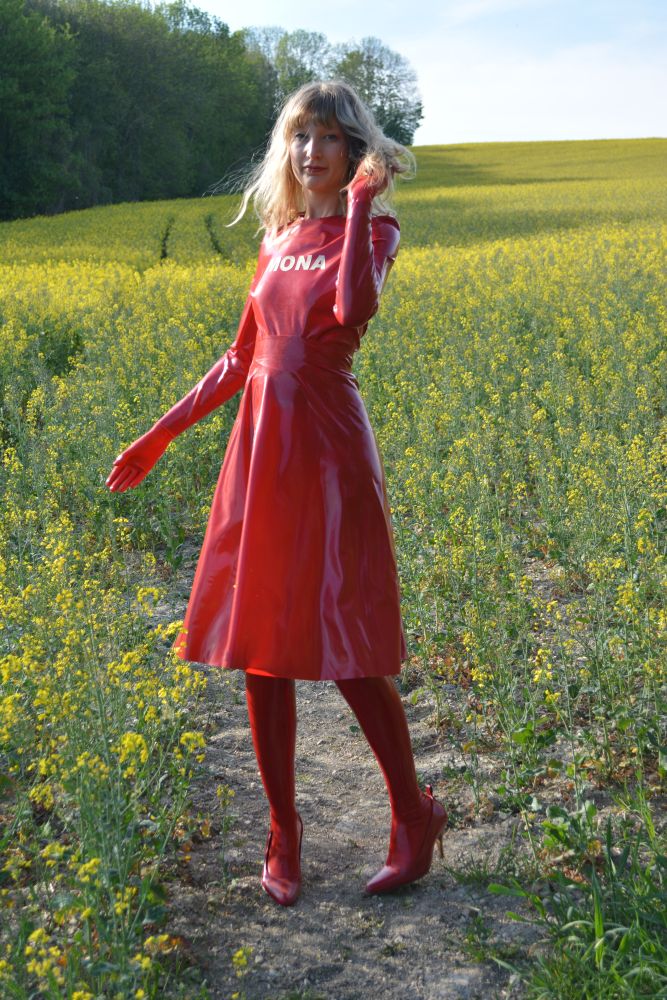 mona in red latex midi skirt in rapeseed fields