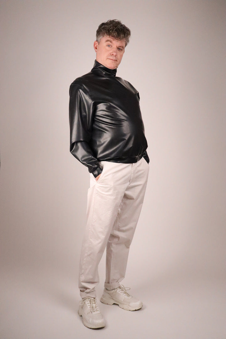 model-pushing-out-his-belly-in-black-latex-turtleneck-sweater