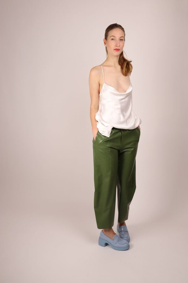 hands-in-pockets-of-green-womens-latex-flat-front-pants